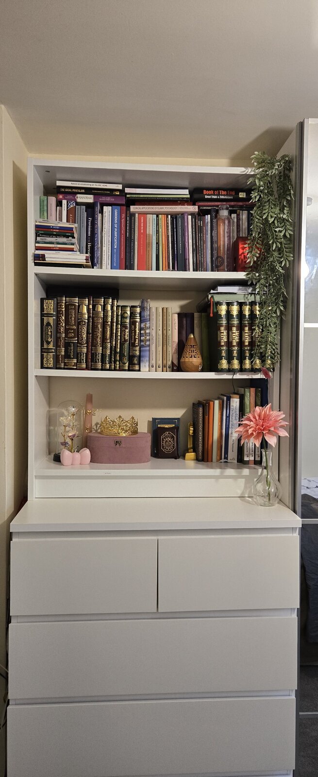 IKEA bookcase assembled and filled with books above a chest of drawers in a London bedroom